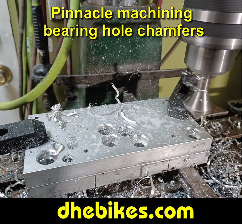 Pinnacle Innovations picture showing machining in progress of the bearing hole tapered chamfers for two Norco custom downhill bike's long travel rear suspension linkage plates made from 6061 aircraft aluminum.

